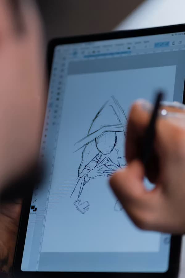 Illustrator sketching a 2D character on a drawing tablet