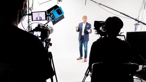 Presenter being filmed in a studio interview setup