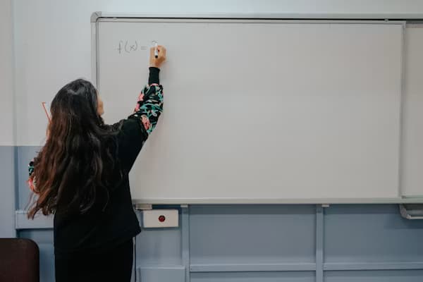 Instructor writing a formula on a whiteboard